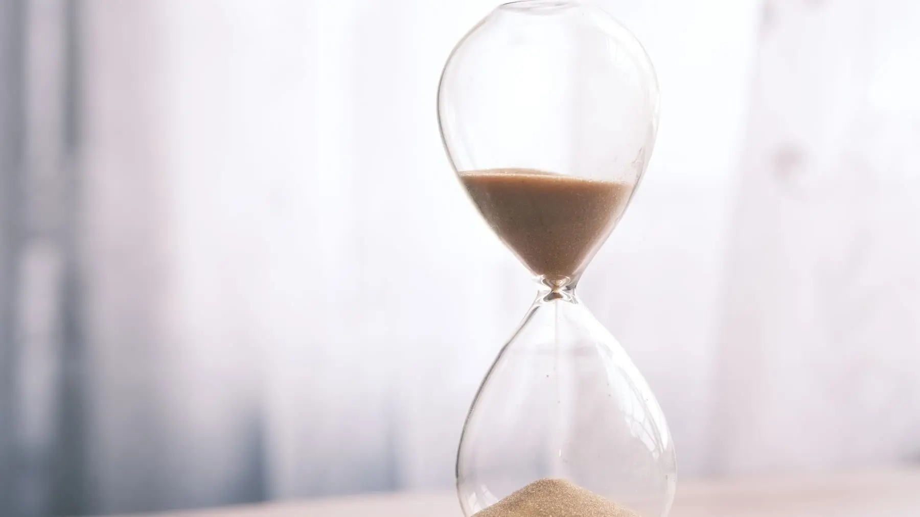 An hourglass with sand running on a table