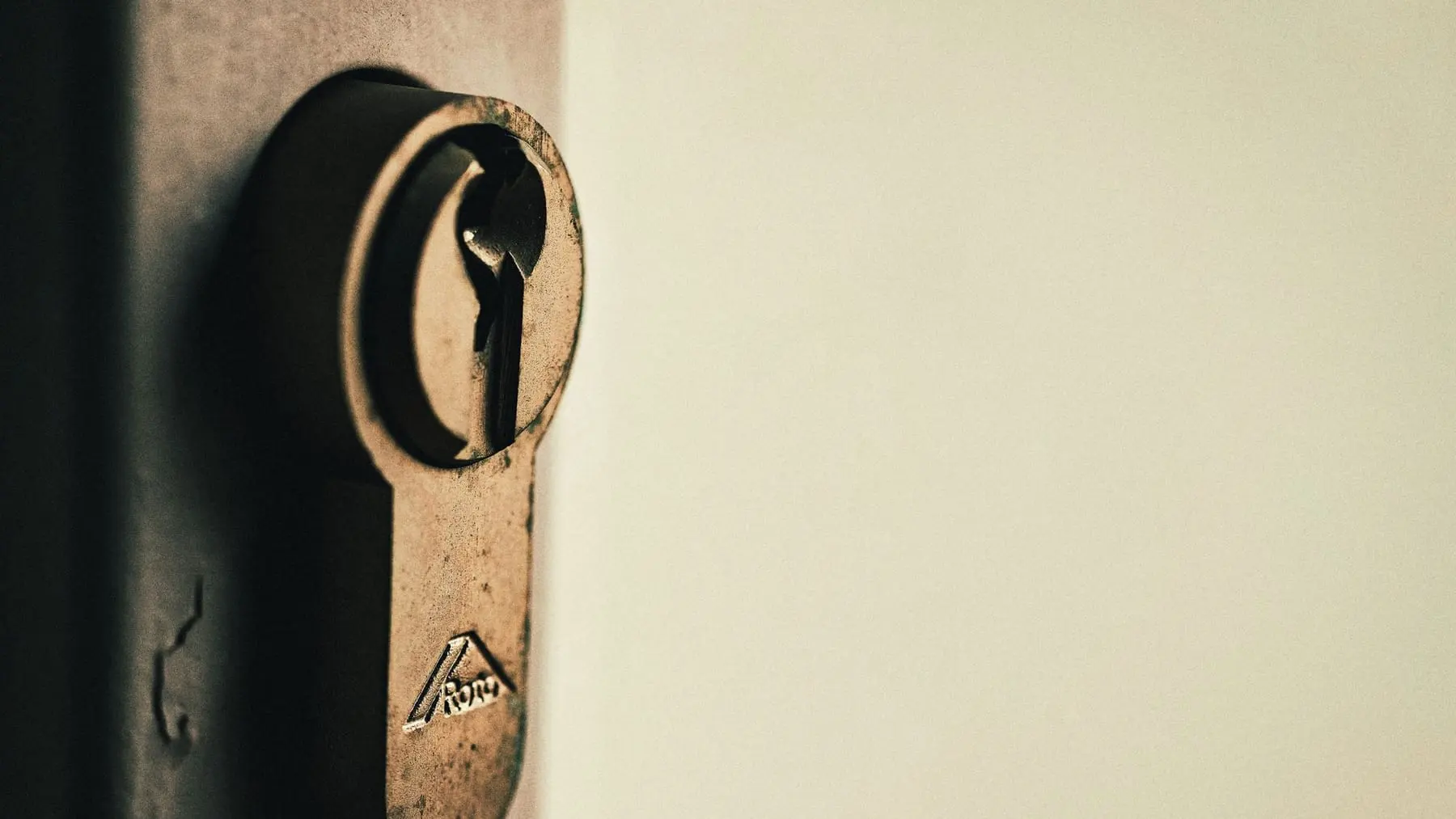 A brass key inserted in a door lock