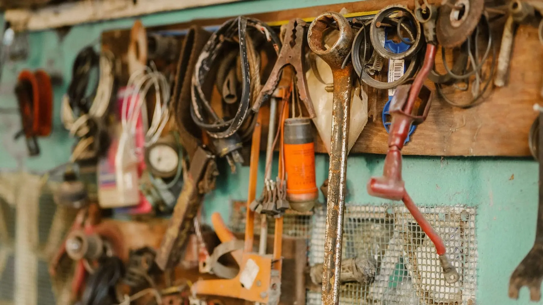 Tools hanging on the wall of a workshop above a workbench